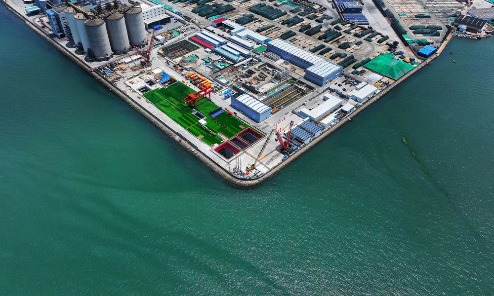 胶州湾第二海底隧道工程是世界上建设规模最大、长度最长的海底道路隧道。工程主线全长17.5公里，西起青岛西海岸新区淮河东路，向东沿刘公岛路下方敷设，穿越胶州湾，至青岛港附近登陆，在海泊河河口以高架桥梁形式衔接青岛东岸城区。其中，隧道长14.37公里（海域段9.95公里），采用双洞双向六车道的主隧道加中间服务隧道的布置方式。隧道盾构段长3253米，使用3台盾构机施工，其中2台直径15.63米的主线隧道盾构机和1台直径8.18米的服务隧道盾构机。图为始发井航拍。