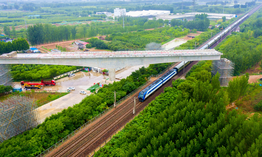 近日，中国中铁旗下中铁四局承建的雄安新区至北京大兴国际机场快线跨京九铁路转体梁顺利合龙，为全线按期通车运营奠定了坚实基础。图为跨京九铁路转体梁转体后火车经过转体桥。