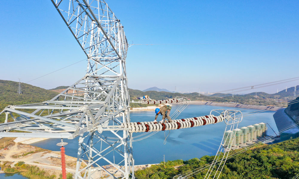据了解，江苏句容抽水蓄能电站预计2025年建成投运，每年发电量可达13.5亿千瓦时，约为53万户家庭一年的用电量。同时，该电站每年可减少二氧化碳排放约35万吨，具有显著的社会效益和环保效益。图为国家电网江苏省送变电有限公司输电人员在高空走线验收消缺。