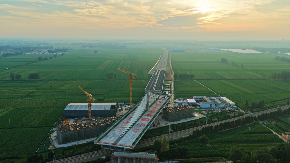 这座转体桥主跨100米、边跨70米，重量达23500吨，历时40分钟逆时针旋转后精准就位，创下山东省首个跨铁路不对称矮塔斜拉转体桥纪录，为项目2025年年底建成通车奠定了坚实基础。图为大桥转体过程中。 