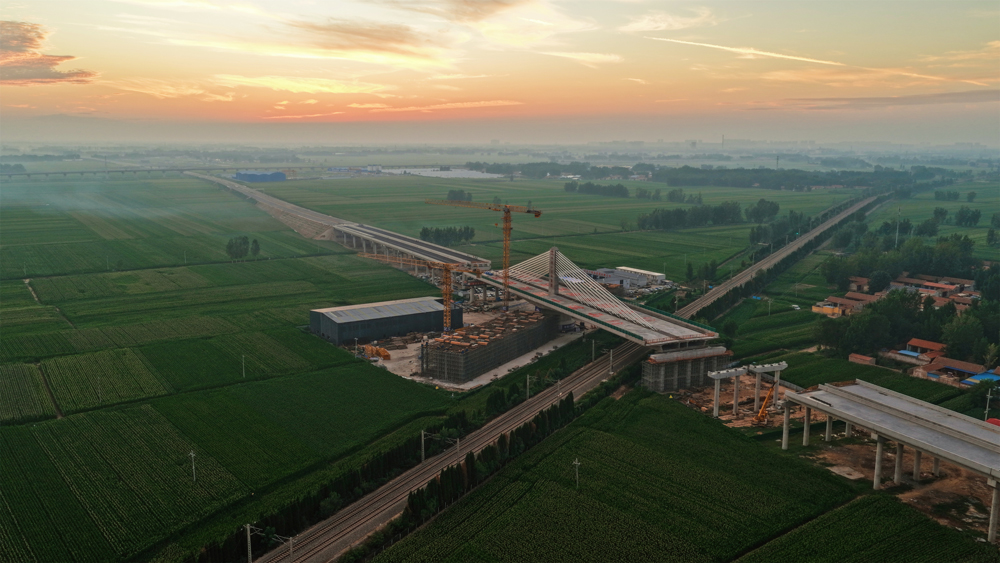 项目团队首创应用“球铰支座+智能牵引”系统，以两台连续千斤顶同步发力，精准驱动重量相当于1.5万辆小汽车的桥体平稳转动。同时运用BIM技术构建三维模型，并依托北斗实时监控系统，对桥梁转角等关键参数实施毫秒级捕捉与动态调整。图为大桥完成转体施工。