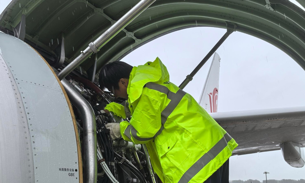 中航集团机务人员手持专业工具，更换FMU（燃油计量单元）传感器。