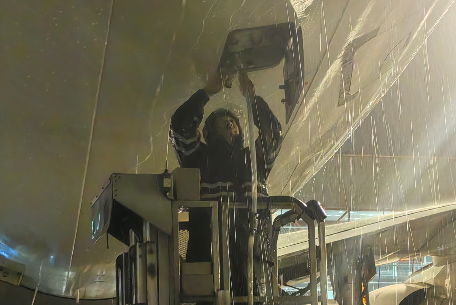 暴雨如注，中航集团水车保障辅助操作员进行加清作业。