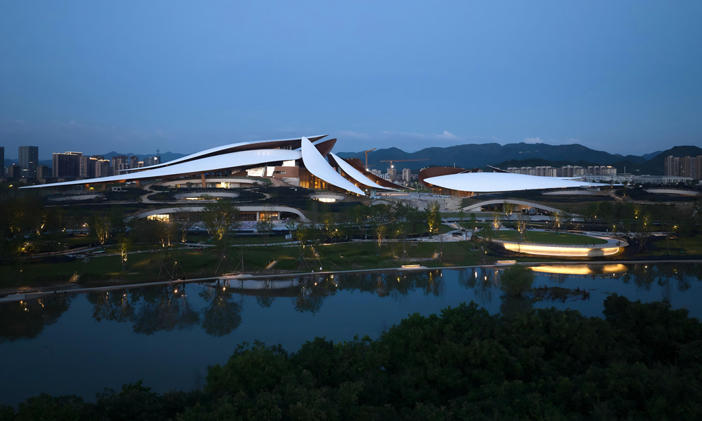 安吉文化艺术中心项目整体设计以“竹叶茶田”为灵感源泉，匠心打造集文化、艺术、休闲于一体的城市综合性地标。十二片灵动竹叶仿佛漂浮于山水之间，形态各异的叶片层叠错落，与幕墙、结构、建筑空间交接关系复杂，它们或舒或卷，将钢筋铁骨定格为大地的诗行，以建筑语言重新诠释竹海文化与江浙气韵。