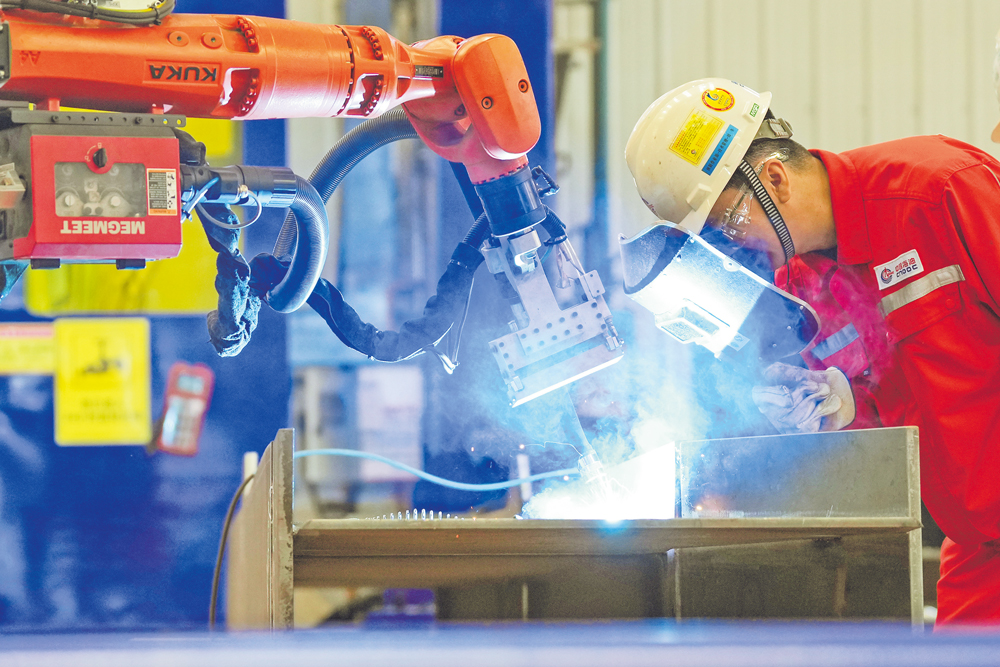 近日，中国海油下属海油工程发布消息，国内首批自主研发海洋工程柔性制造智能焊接机器人设备系统在天津集成完工，进入测试验收阶段，标志着我国海洋油气装备关键节点柔性制造技术取得重大突破，对加快培育发展海洋能源新质生产力具有重要意义。 图为工作人员近距离观察焊缝细节。