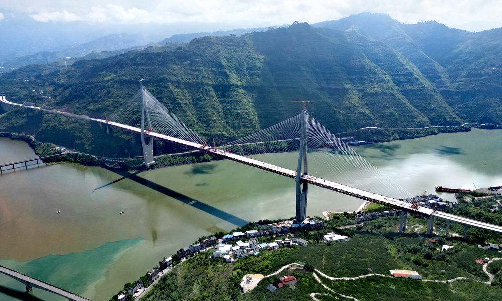 新市金沙江特大桥，起点位于四川屏山新市镇，终点在云南绥江南岸镇，为双塔双索面钢桁梁斜拉桥，全长1867米，其中主桥长1288米，引桥长579米，主跨达680米，大桥云南岸索塔高达297.51米，刷新了川滇两省桥梁索塔高度纪录。