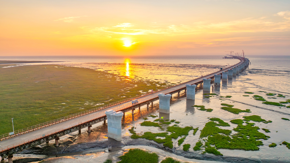 落日熔金，蜿蜒的桥墩如长龙静卧杭州湾。目前，中交二航局参建的世界最长铁路跨海桥梁——杭州湾跨海铁路大桥桩基基础施工已完成，正全面转入塔柱施工、箱梁架设等上部结构施工阶段。