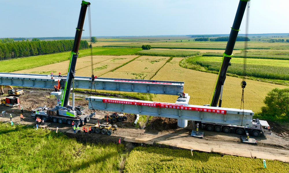 此次进入架梁阶段的佳木同江特大桥位于同江至同江北改建段，是全线控制性工程，桥梁全长10435.14米，采用单线T梁结构设计，是我国目前中欧班列三大通道中口岸段最长新建桥梁。图为架桥机在架设梁体。