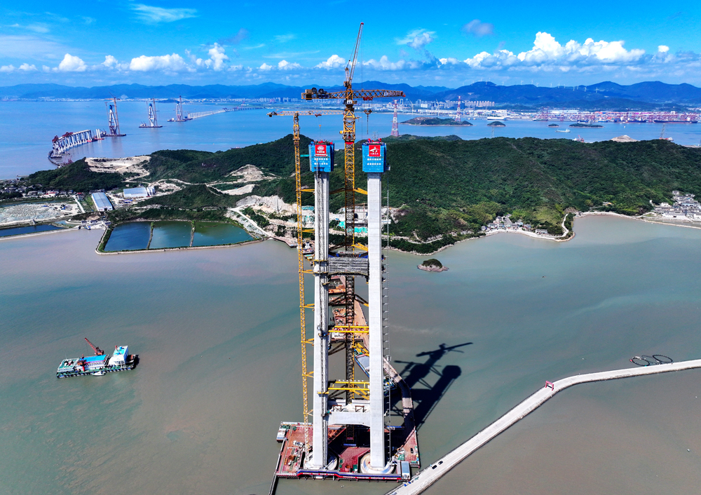 此次成功封顶的佛渡侧索塔为海上主塔，塔高254米，是全线最高桥塔。该塔施工条件复杂、技术难度极高，共分43个节段建设，累计浇筑混凝土约6万立方米，预埋型钢5261吨，钢筋用量达8625吨。图为双屿门大桥佛渡侧主塔施工现场。