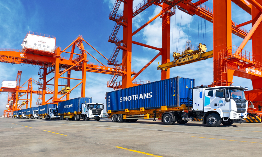 “十四五”时期，招商局集团旗下中国外运持续提升产业链供应链韧性与安全水平，自有海外服务网络覆盖全球45个国家和地区；稳定运营全货机定期国际航线，年度固定运力约26万吨；国际班列运量累计突破200万标箱，汽运网络覆盖全国各省份超300个城市，自动驾驶高速干线商业运营里程超300万公里。图为自动驾驶电动集卡车队行驶在中国外运江门高新港。