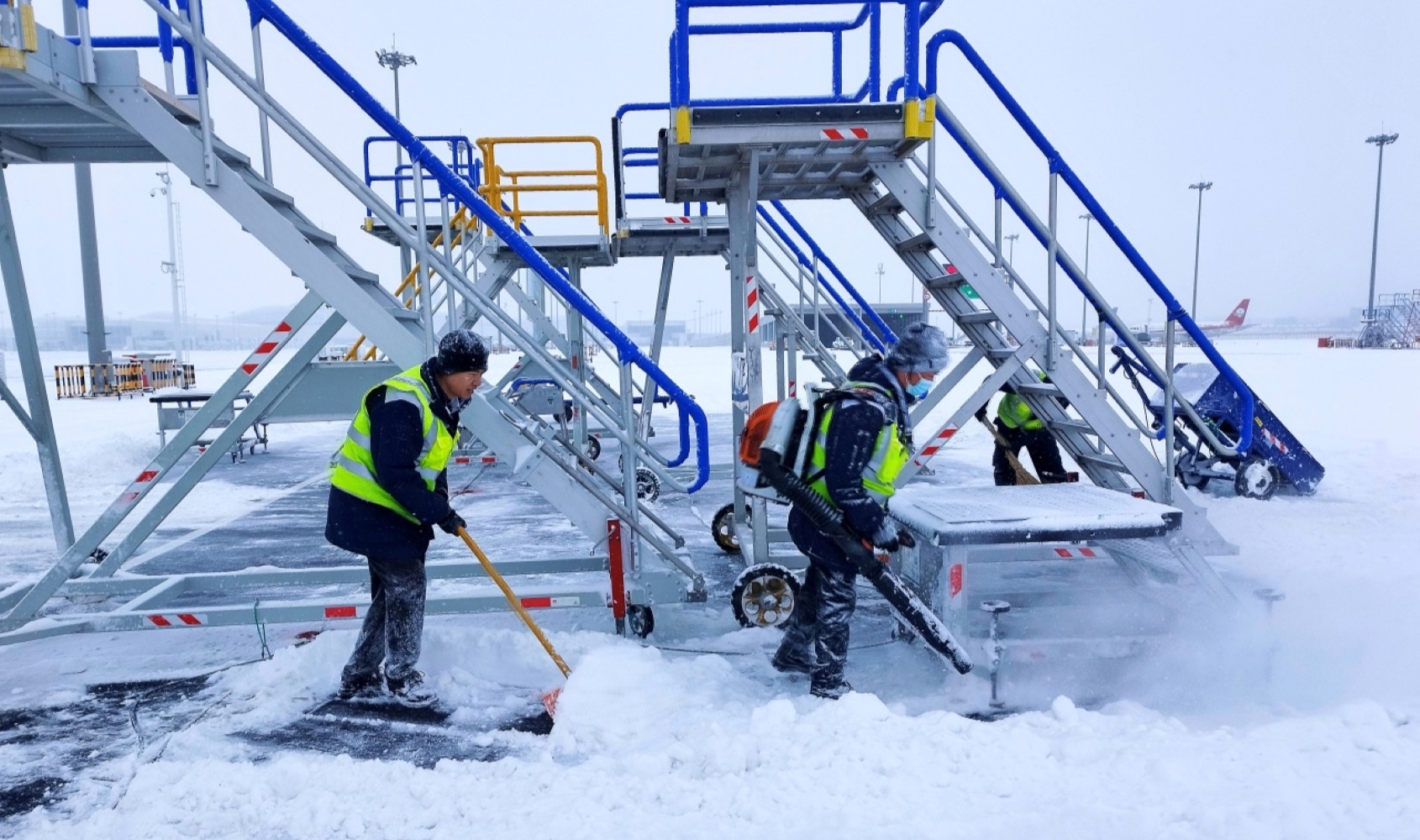 在乌鲁木齐天山国际机场，中航集团工作人员清除机坪积雪。