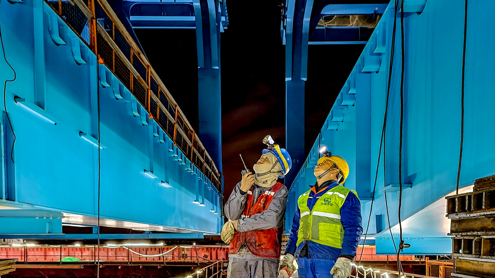 崇启公铁长江大桥横跨长江入海口北支航道，是沪渝蓉高速铁路沪宁段控制性工程。施工过程中，项目建设团队应用自主研制的多点自适应同步顶推控制系统，实现模数驱动、一键顶推、自动纠偏与智能预警，确保钢梁顶推全程智能、精准施工。