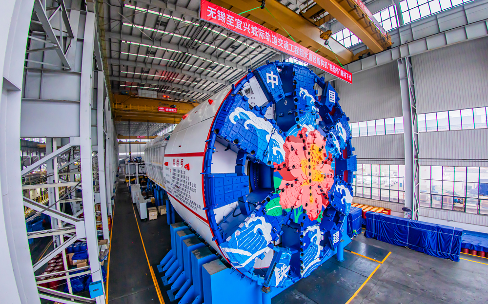 锡宜S2线全长约61.48公里，设计时速160公里，将“两进两出”穿越太湖。其中，穿太湖段隧道为工程核心控制性节点，将采用泥水平衡盾构机施工，是国内首条穿太湖超大直径盾构隧道。图为“熙怡号”盾构机下线现场。