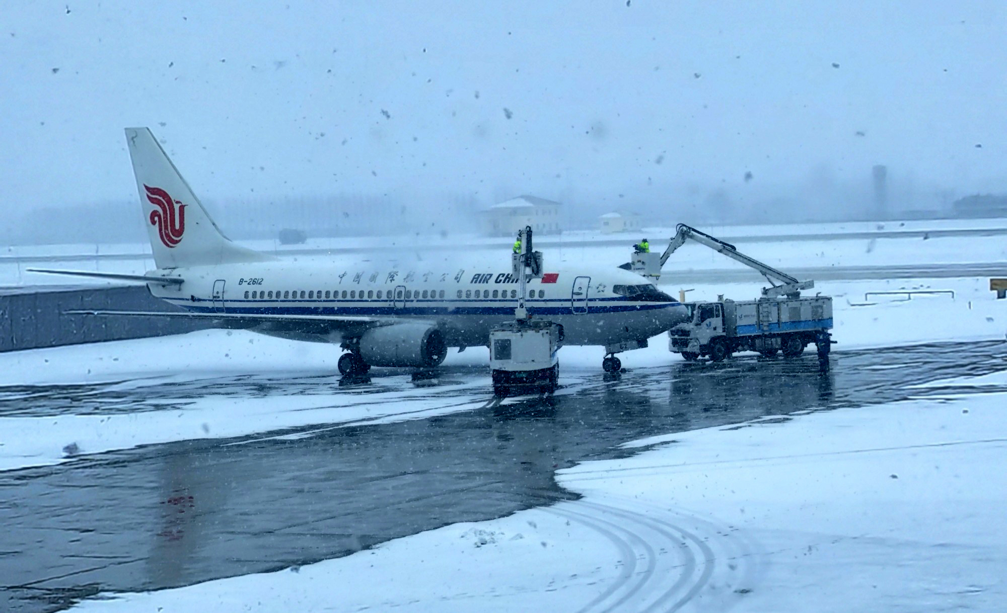 在山东威海机场，中航集团工作人员对飞机开展除冰作业。