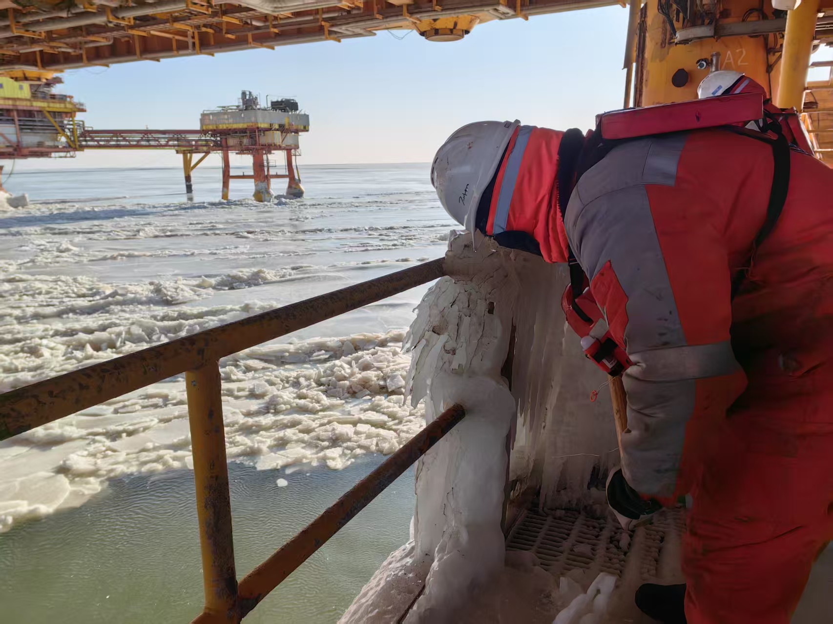 锦州9-3油田以“前置预警—动态处置—现场指挥”为核心思路，工作人员24小时坚守岗位，利用信息化手段提升防冰作业的精准性与时效性。图为工作人员清理冰凌。